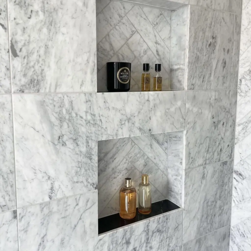 badrum med carrara-marmor på väggarna
