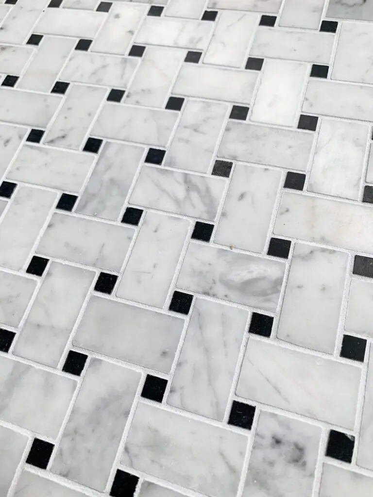 marmormosaik i carrara och svart marmor i flätmönster