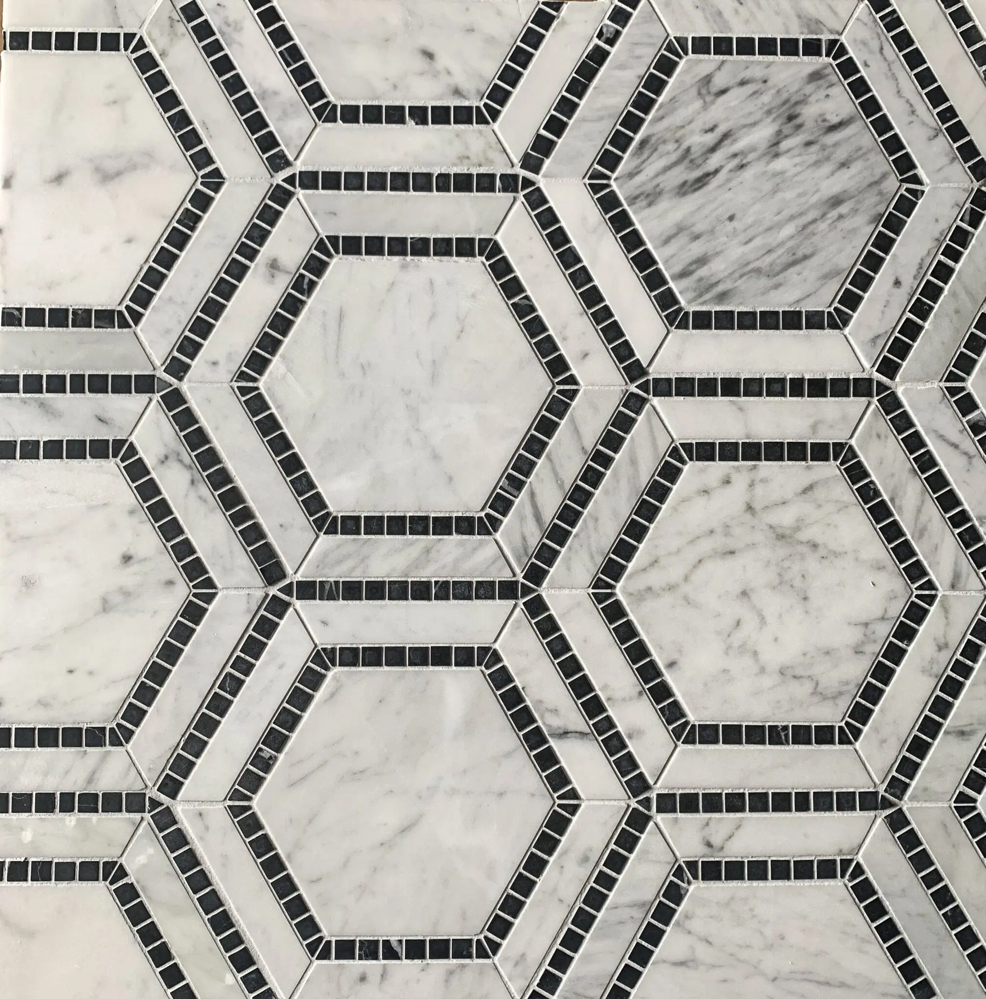 marmormosaik i form av hexagoner i carrara och svart marmor