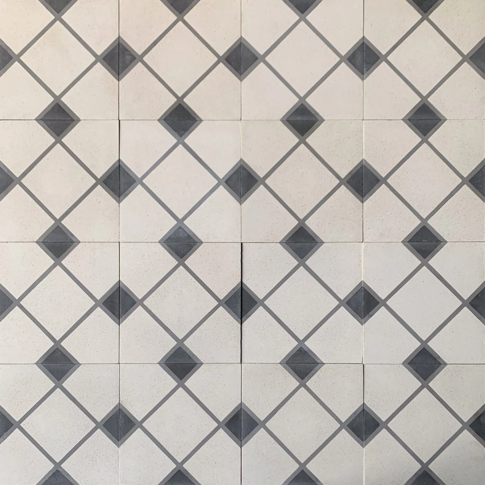 klassiskt mönstrat cementgolv med romber i vitt, svart och grått