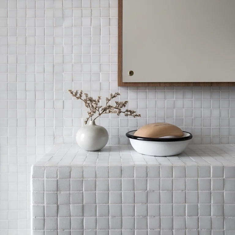 badrum med vägg och bänk täckt av vit keramikmosaik