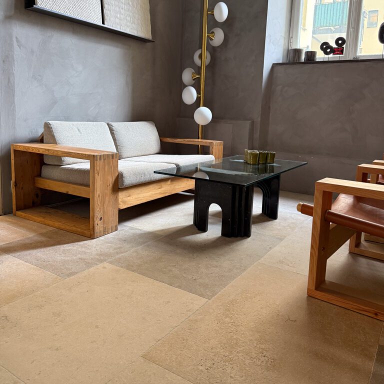 Vardagsrum med beige och grått antikbehandlat kalkstensgolv