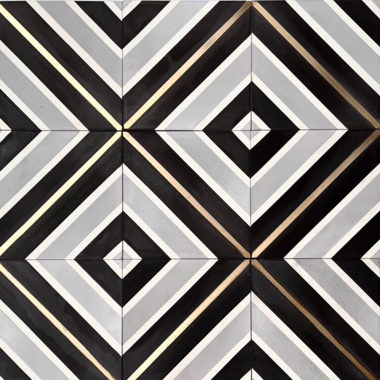 mönstrat cementgolv i grått, svart och vitt med inlägg av mässing