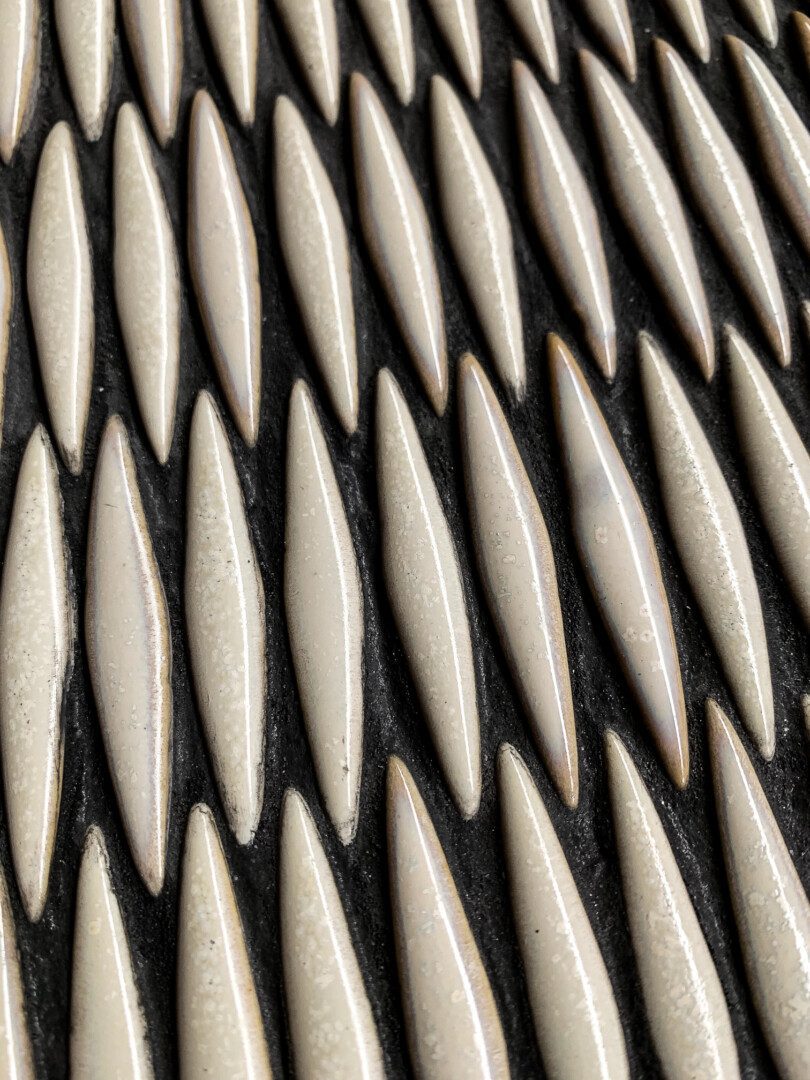 närbild av pärlemofärgad keramikmosaik i form av spetsiga ovaler