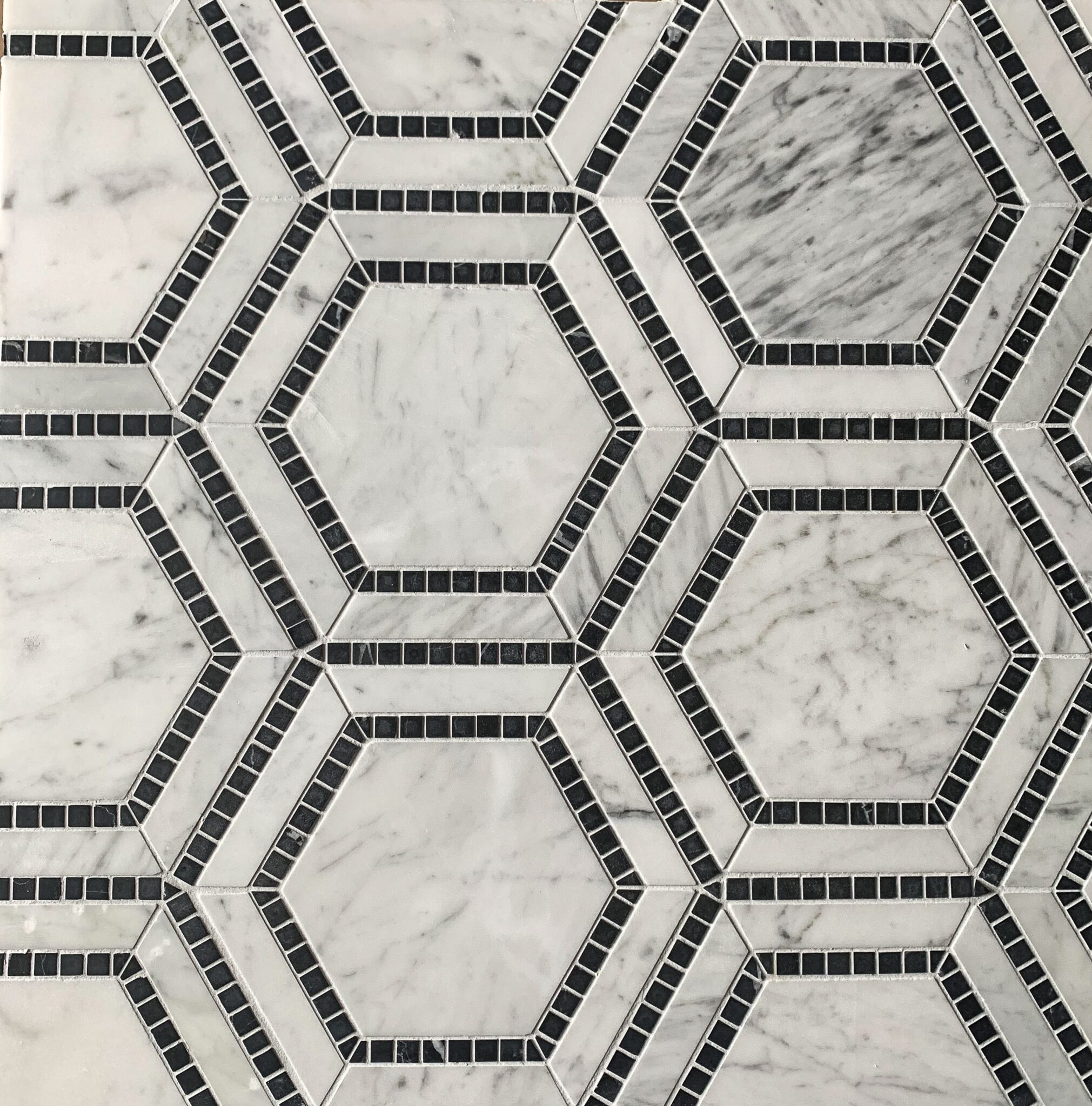 marmormosaik i form av hexagoner i carrara och svart marmor