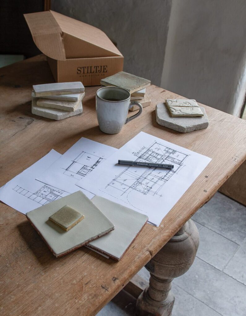Byggnadsritningar tillsammans med materialprover på kakel, tegel, kalksten och keramikmosaik