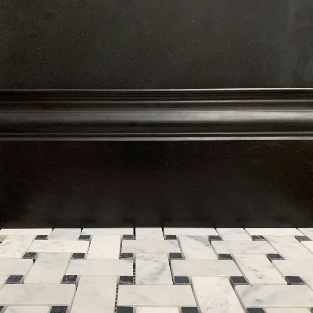 golvlist i svart marmor med golv i marmormosaik