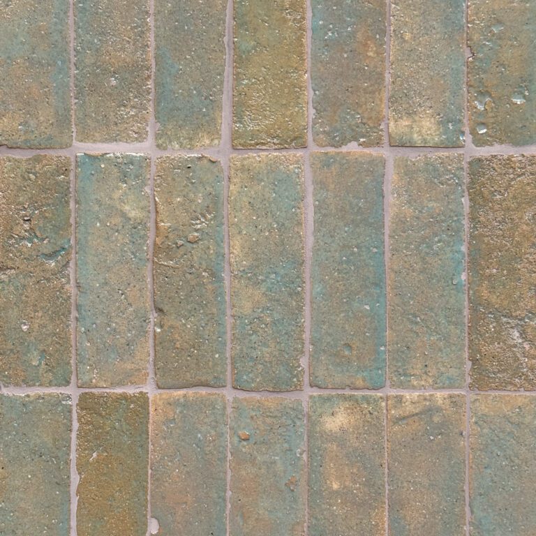 närbild av ett glaserat tegelgolv med turkosa nyanser som skapar en livfull atmosfär.