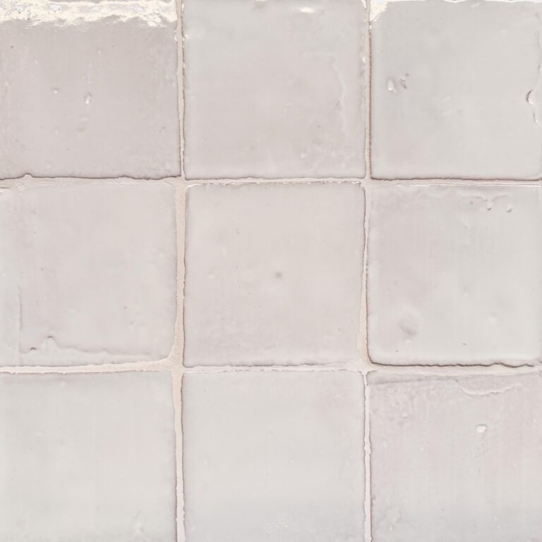 krämfärgat handgjort kakel på vägg