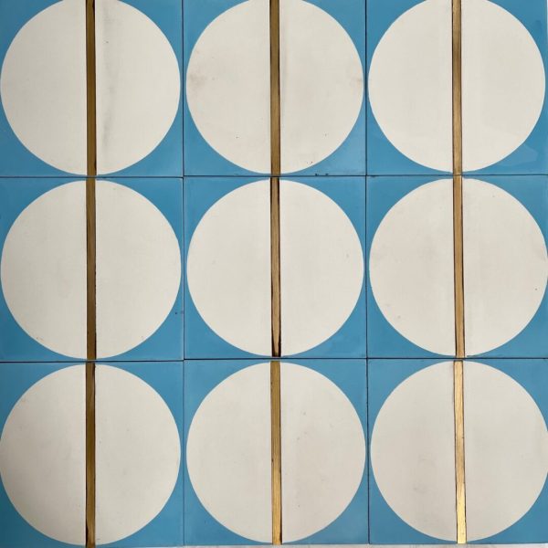 mönstrat cementgolv i blått och vitt med inlägg av mässing