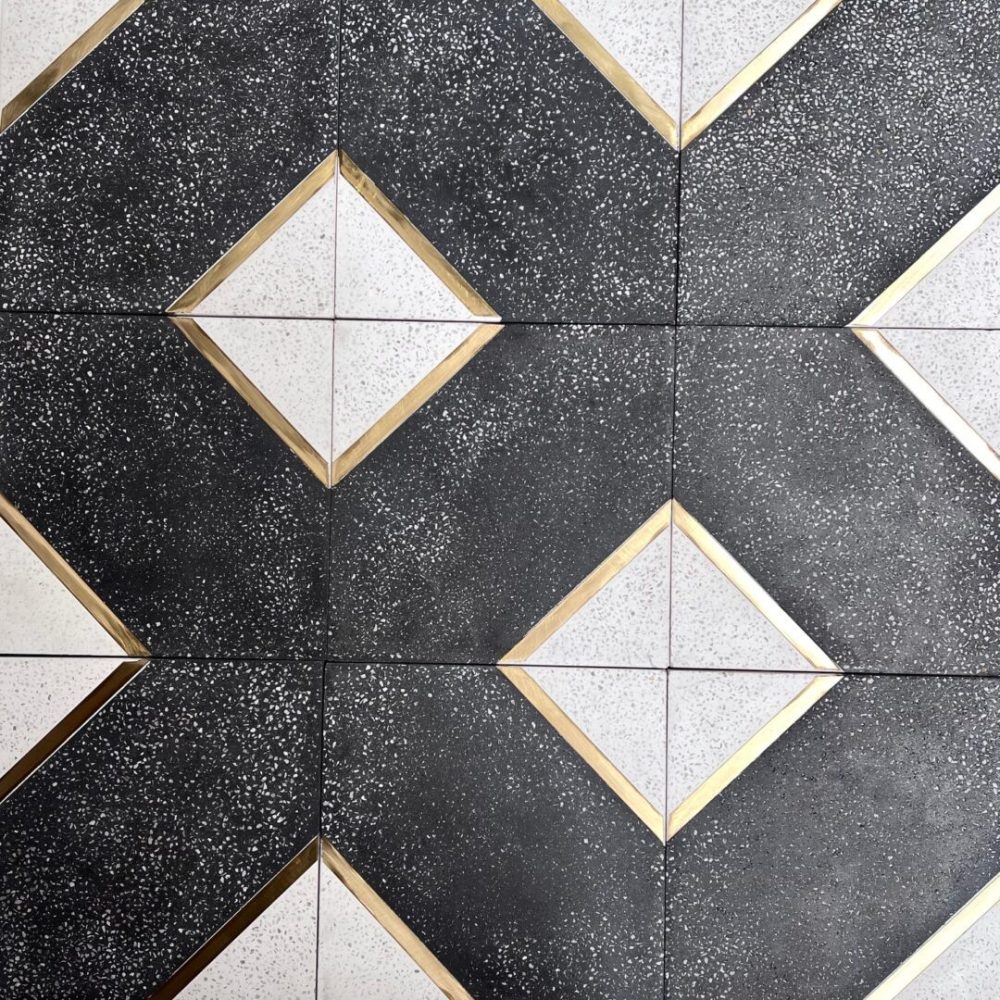 cementgolv i svart och vitt med terazzo och inlägg av mässing