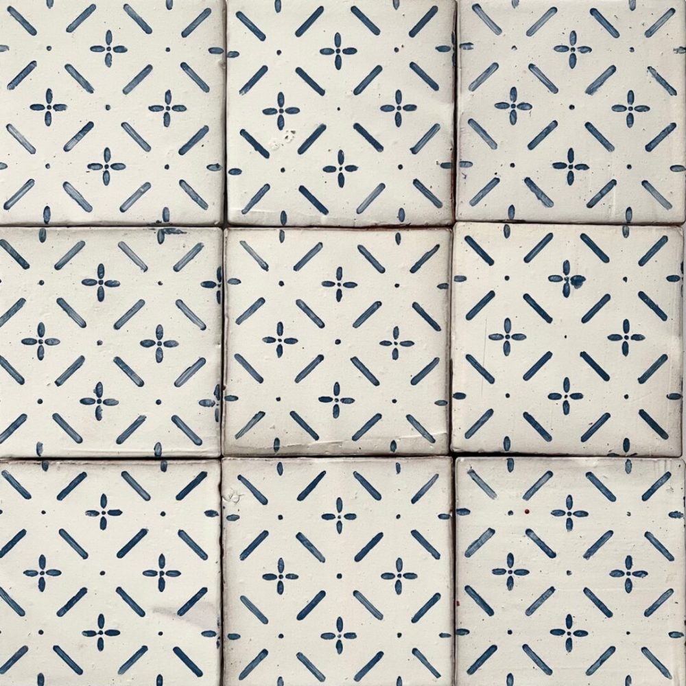 Handmålat kakel med vit bakgrund och blått mönster