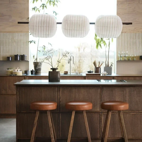 modernt japandi kök med mörka träluckor och avlångt vitt kakel