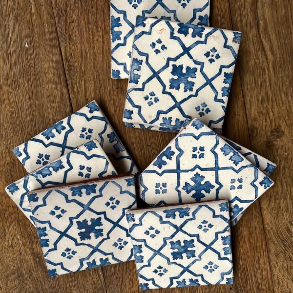 Handmålat kakel med vit bakgrund och blått mönster