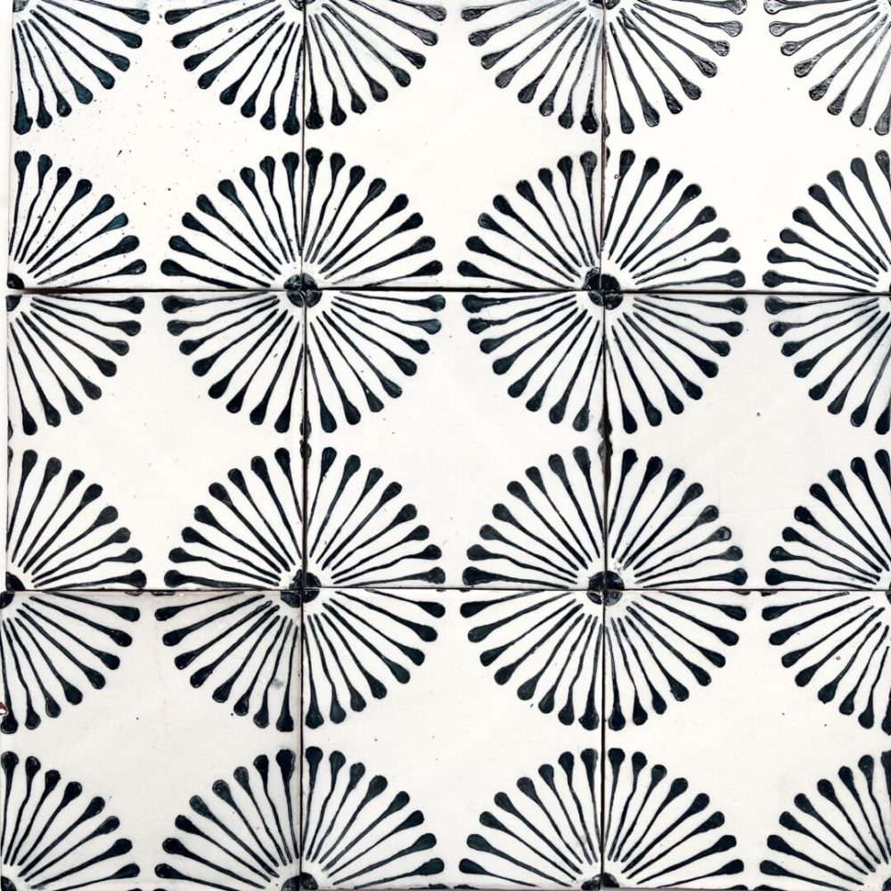 kakel med vit bakgrund och handmålade blommor i svart