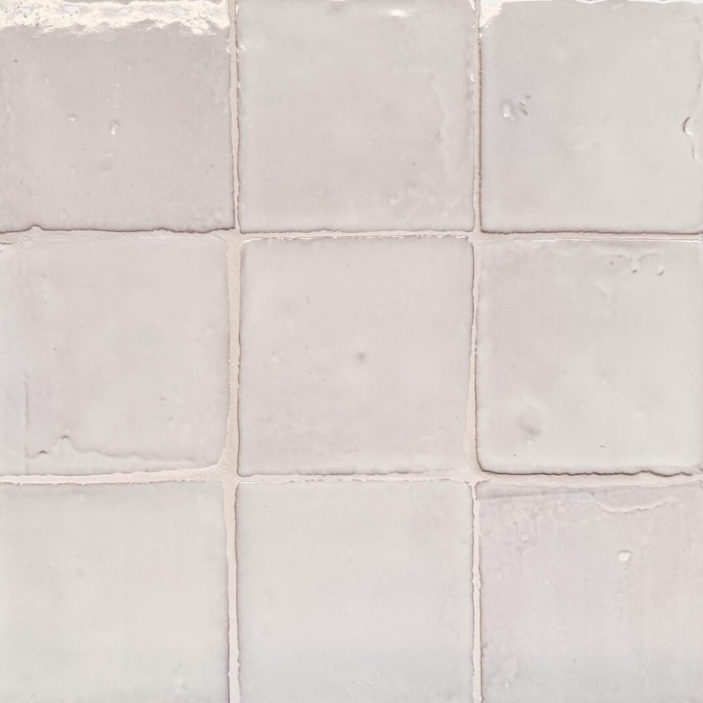 krämfärgat handgjort kakel på vägg