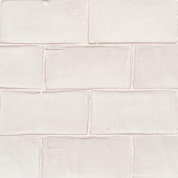 krämfärgat handgjort kakel på vägg