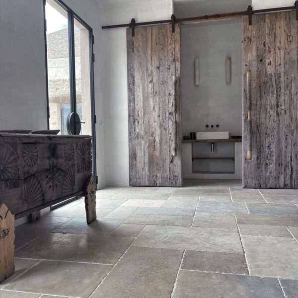 sovrum med antikbehandlat kalkstensgolv i blandade storlekar