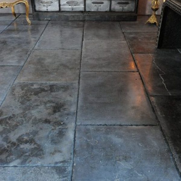 mörkt rustikt kalkstensgolv med huggna kanter