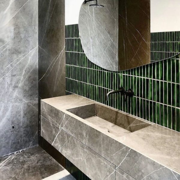 badrum med grön keramikmosaik på väggarna