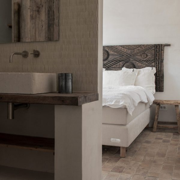 sovrum med rustikt tegelgolv och krämfärgad keramikmosaik på vägg