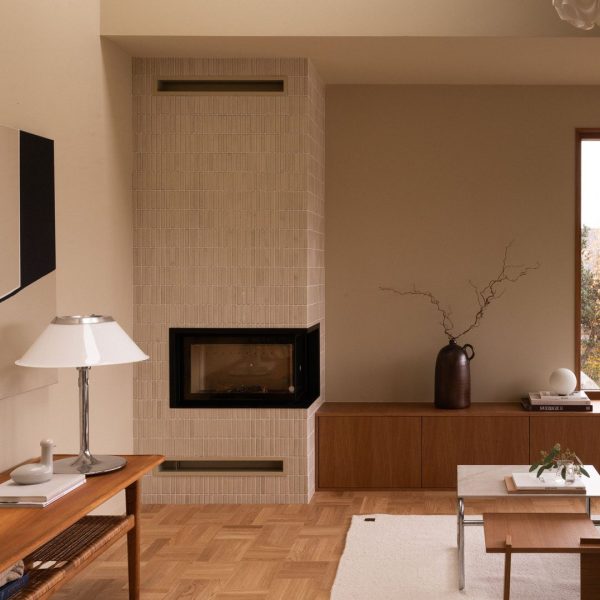 vardagsrum med en öppen spis täckt av krämfärgat kakel