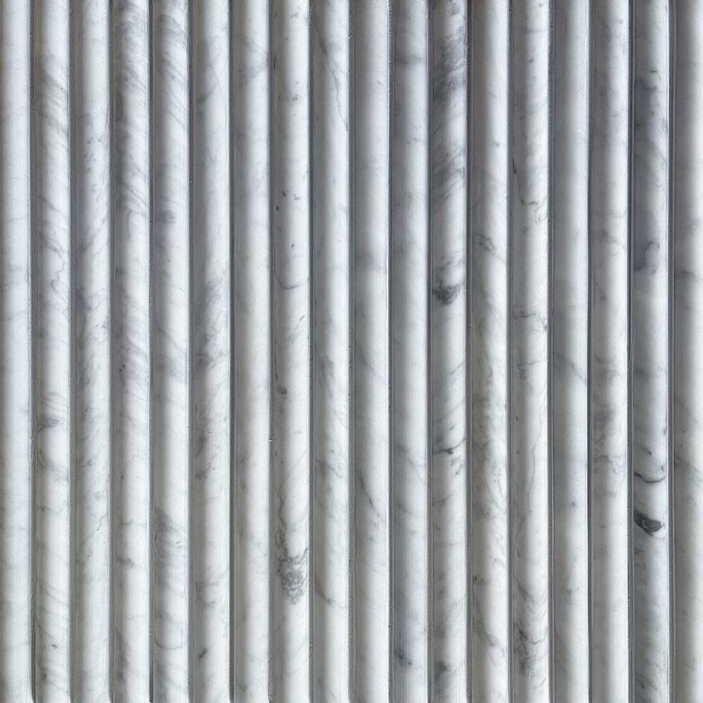 Mosaik av rundade stavar i carrara marmor med ljusgrå fog