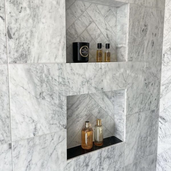 badrum med carrara-marmor på väggarna