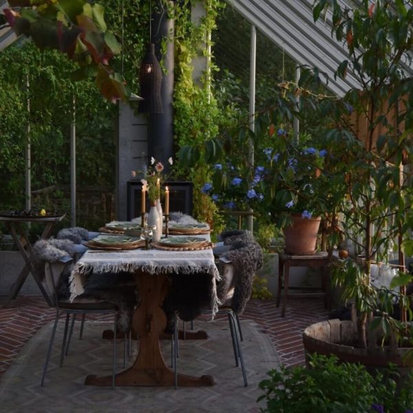 Växthus med matplats och rött tegel i fiskbensmönster på golvet