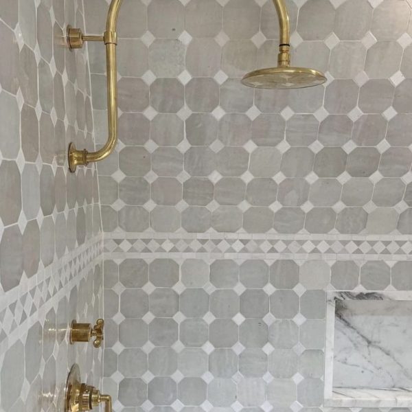 dusch med zellige på väggarna och en inbyggd hylla i marmor