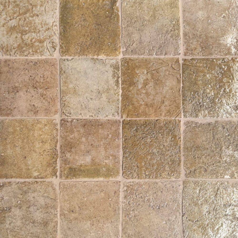 närbild av ett glaserat tegel med rosa och beiga nyanser som skapar en livfull atmosfär.