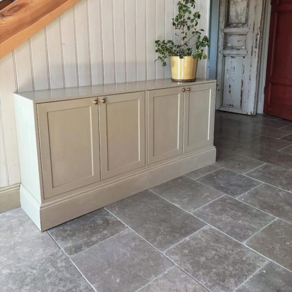 hall med grå tumlad kalksten på golvet i blandade storlekar