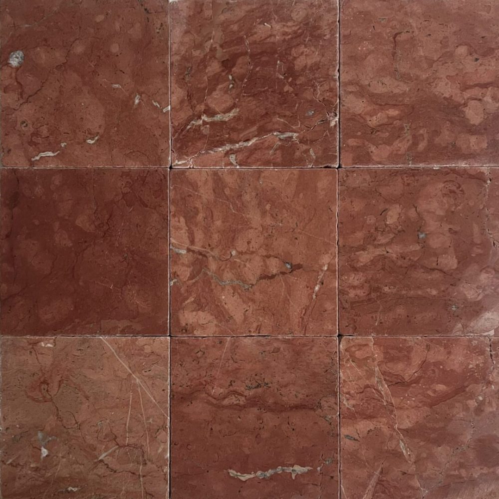 röd tumlad marmor på golv