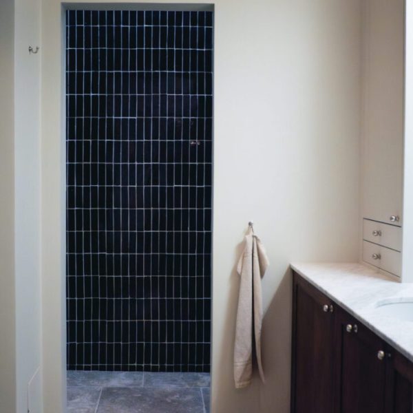 mörkbrunt marockanskt zellige-kakel på vägg i dusch och kalksten på golvet