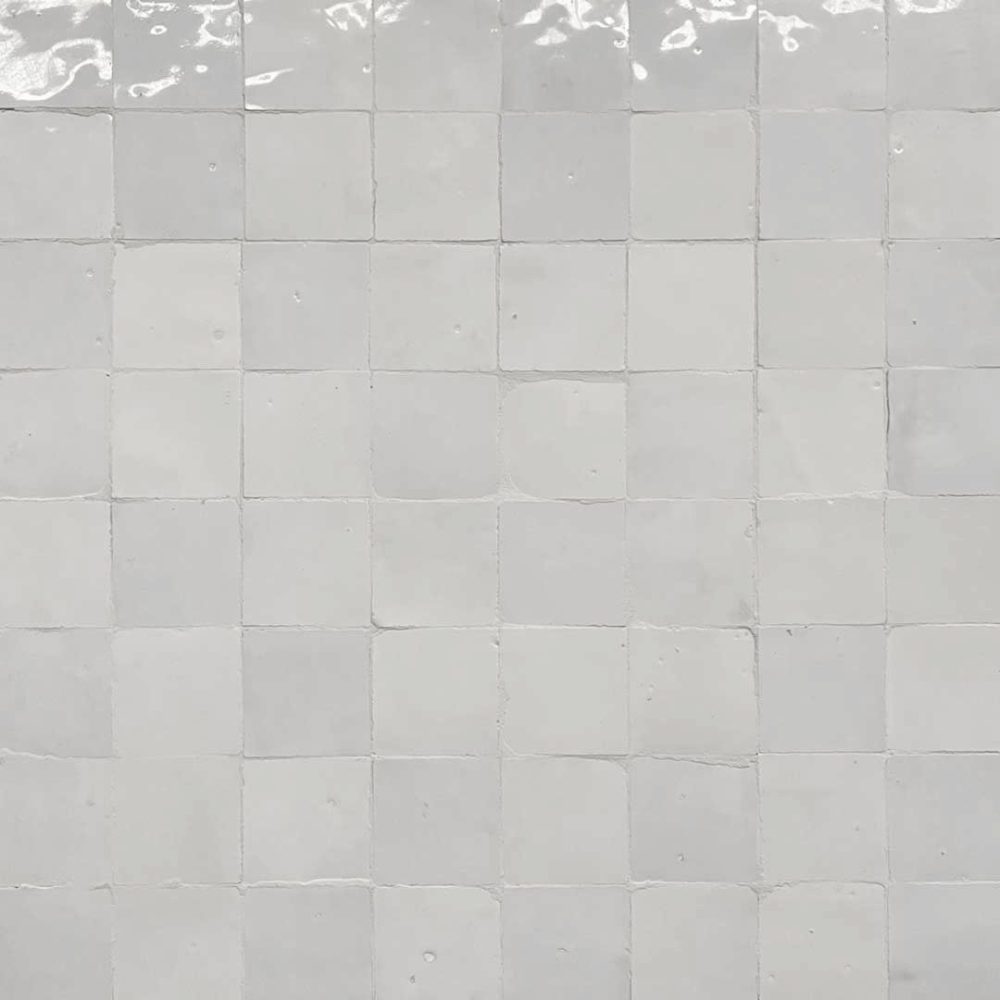 närbild på vita ojämna glansiga zellige-kakelplattor