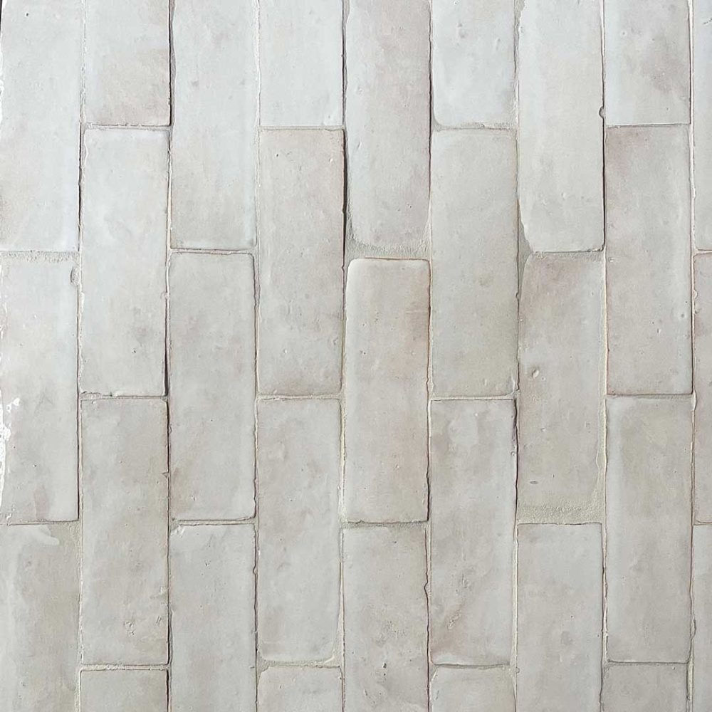 avlångt zellige-kakel med en något transparent vit glasyr där kaklets naturliga färg lyser igenom